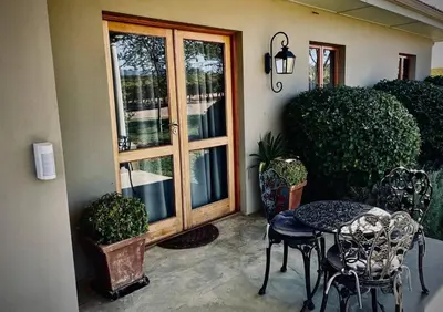a patio with a table and chairs next to a door at Belle Vallee Guestroom 1 in Wellington