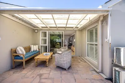 a living room with a patio with awning at The Island Beach House in Cape Town
