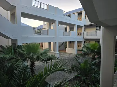 an external view of a building with palm trees at 118 on the Bay in Gordonʼs Bay