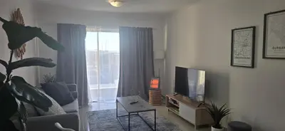 a living room with a couch and a television at 118 on the Bay in Gordonʼs Bay
