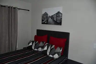 a bedroom with a bed with red pillows at Avon Sand in Cape Town