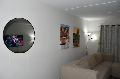 a living room with a white couch and a mirror at Avon Sand in Cape Town