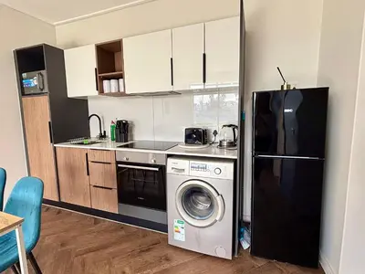 a kitchen with a washing machine and a refrigerator at Modern chic at On park Century City near Canal Walk in Cape Town