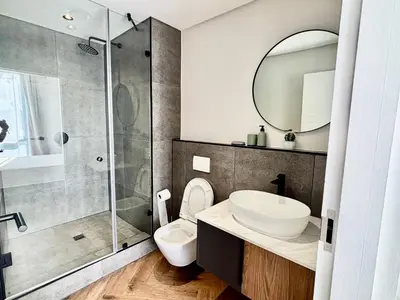 a bathroom with a toilet and a sink and a shower at Modern chic at On park Century City near Canal Walk in Cape Town