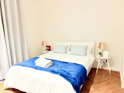 a bedroom with a large white bed with blue sheets at Modern chic at On park Century City near Canal Walk in Cape Town