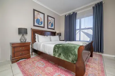 a bedroom with a large bed and a window at Prime Executive Apartments 2 in Durbanville