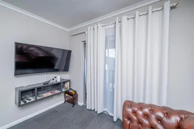 a living room with a couch and a large window at Prime Executive Apartments 2 in Durbanville