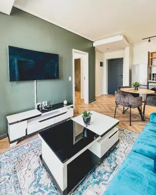 a living room with a couch and a table at Agape Apartment On park Century in Cape Town