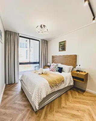 a bedroom with a large bed and a large window at Agape Apartment On park Century in Cape Town