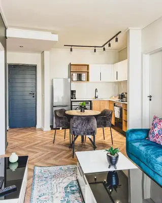 a living room with a couch and a table at Agape Apartment On park Century in Cape Town