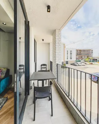 a balcony with a table and chairs on a building at Agape Apartment On park Century in Cape Town