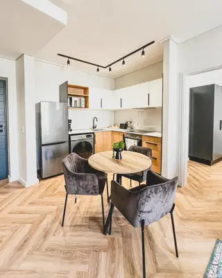 a kitchen and dining room with a table and chairs at Agape Apartment On park Century in Cape Town