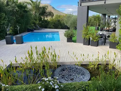 a swimming pool in a garden with plants at Stellenbosch Rozendal Apartment in Stellenbosch