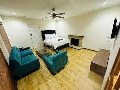 a bedroom with a bed and a couch and chairs at Joy House in Cape Town