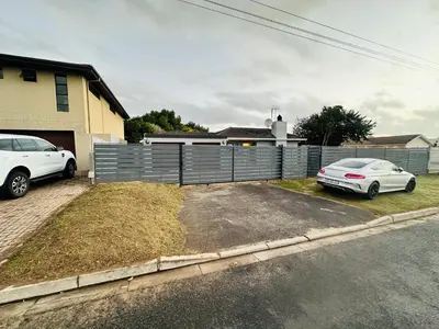 two cars parked in a driveway in front of a house at Joy House in Cape Town