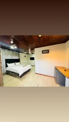 a bedroom with a white bed and a desk at Joy House in Cape Town