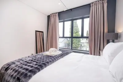 a bedroom with a bed and a large window at Paarl Studio With Onsite Parking & Modern Comforts in Paarl
