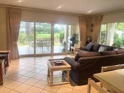 a living room with a couch and a table at Golfers paradise on 25th green in Hermanus