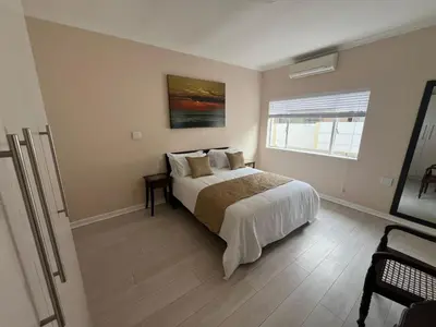 a bedroom with a large bed and a window at Minak Guest House Bellville in Bellville