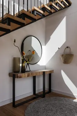 a mirror on a table under a staircase at Tide and Timber Luxury Guesthouse in Hermanus