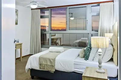 a bedroom with a bed and a large window at Panoramic Seaview @ Strand in Strand