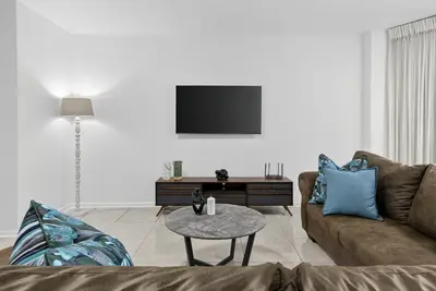 a living room with a couch and a table at Panoramic Seaview @ Strand in Strand