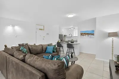 a living room with a couch and a kitchen at Panoramic Seaview @ Strand in Strand