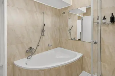 a bathroom with a shower and a white sink at Panoramic Seaview @ Strand in Strand