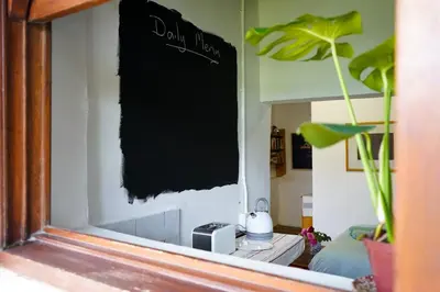 a mirror in a living room with a sign on the wall at The Little Gallery in Villiersdorp