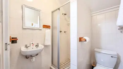 a bathroom with a toilet and a sink and a shower at Rivers Edge Loft in Wellington