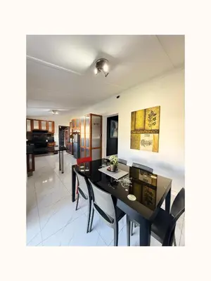 a living room with a dining room table and chairs at Rihla Residences - Civic Road in Cape Town