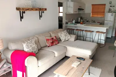 a living room with a couch and a table at Stylish Apartment in Hermanus in Hermanus