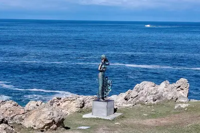 a statue of a person standing on top of the ocean at Stylish Apartment in Hermanus in Hermanus