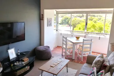 a living room with a table and a dining room at Stylish Apartment in Hermanus in Hermanus