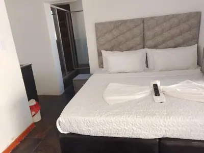 a bedroom with a bed with a remote control on it at Duminy Lodge Monthly Rentals in Bellville
