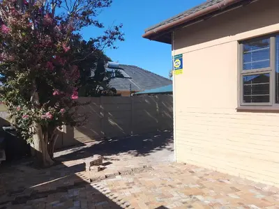 a house with a fence and a tree next to it at Duminy Lodge Monthly Rentals in Bellville
