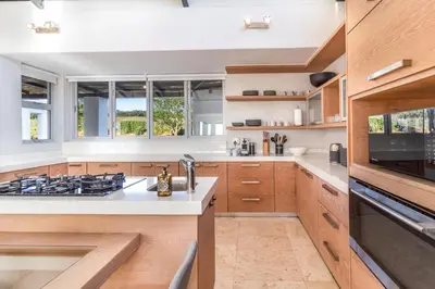 a kitchen with white countertops and wooden cabinets at Modern Home with Views, Pool & Fireplaces in Estate in the Wineland