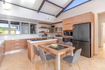 a kitchen with a wooden table and a black refrigerator at Modern Home with Views, Pool & Fireplaces in Estate in the Wineland