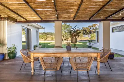 an outdoor dining room with a wooden table and chairs at Modern Home with Views, Pool & Fireplaces in Estate in the Wineland
