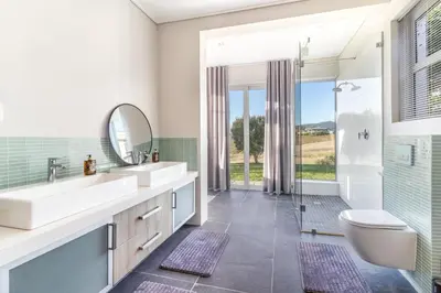a bathroom with two sinks and a toilet and a shower at Modern Home with Views, Pool & Fireplaces in Estate in the Wineland