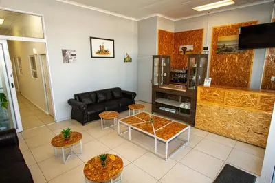 a living room with a couch and a table at Lodge Luxe, Cozy Bedrooms, Free WiFi, Robust Security in Cape Town