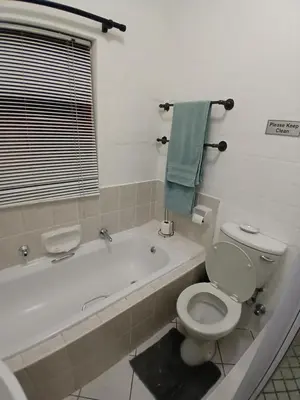 a bathroom with a toilet and a bath tub with a sink at Fisherman's Haven in Bloubergstrand