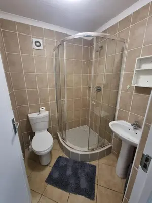 a bathroom with a shower and a toilet and a sink at 180 Mont Blanc in Gordonʼs Bay