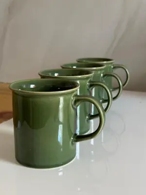 three green coffee mugs sitting on a table at 3 Uitsig Street, Rozendal, Stellenbosch in Stellenbosch