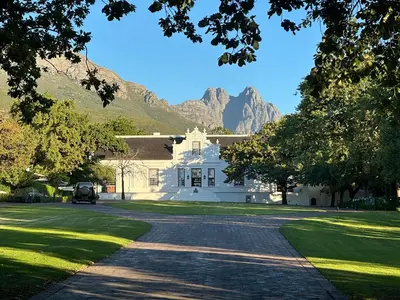 a large white house with mountains in the background at 3 Uitsig Street, Rozendal, Stellenbosch in Stellenbosch