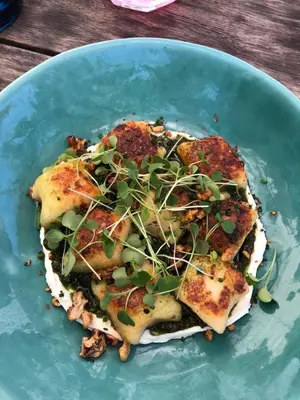 a blue plate with a dish of food on a table at 3 Uitsig Street, Rozendal, Stellenbosch in Stellenbosch