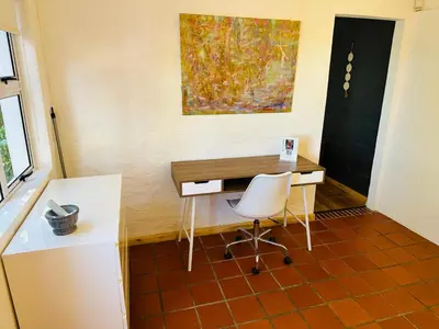 a desk and a chair in a room with a painting at 3 Uitsig Street, Rozendal, Stellenbosch in Stellenbosch