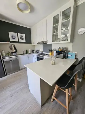 a kitchen with a large white island in a room at At Leisure Apartment 2 in Stellenbosch