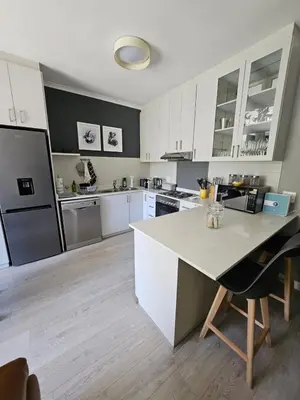 a kitchen with white cabinets and a white counter top at At Leisure Apartment 2 in Stellenbosch