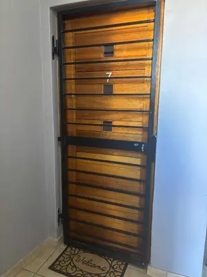a wooden closet door in a room with a rug at At Leisure Apartment 2 in Stellenbosch